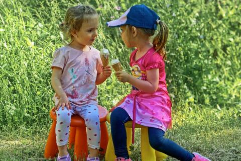 Two girls with ice creams. The Thai for "two girls with ice creams" is "เด็กหญิงสองคนและไอศกรีม".