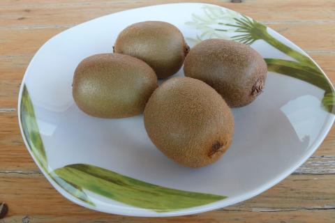 Four kiwis on a plate. The Thai for "four kiwis on a plate" is "กีวีสี่ลูกบนจาน".