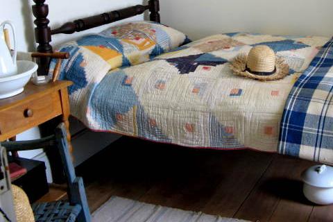 A straw hat on a bed. The Thai for "a straw hat on a bed" is "หมวกฟางบนที่นอน".