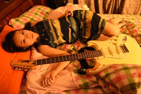 A woman and her guitar on a bed. The Thai for "a woman and her guitar on a bed" is "ผู้หญิงและกีตาร์ของเธอบนที่นอน". A woman and her guitar on a bed. The Thai for "a woman and her guitar on a bed" is "ผู้หญิงและกีตาร์ของเธอบนที่นอน".