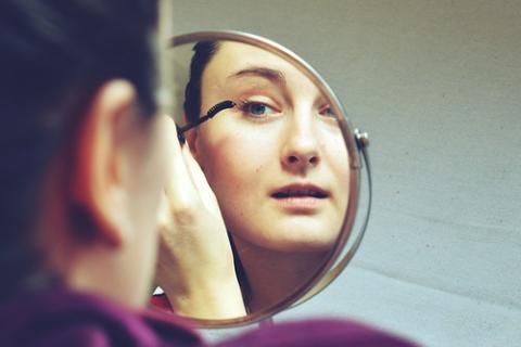 A woman putting on make up. The Thai for "a woman putting on make up" is "ผู้หญิงกำลังแต่งหน้า".
