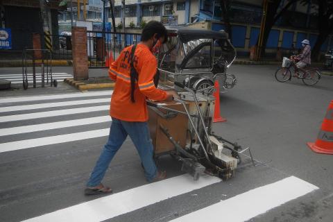 A worker painting a zebra crossing. The Thai for "a worker painting a zebra crossing" is "คนงานกำลังทาสีทางม้าลาย". A worker painting a zebra crossing. The Thai for "a worker painting a zebra crossing" is "คนงานกำลังทาสีทางม้าลาย".
