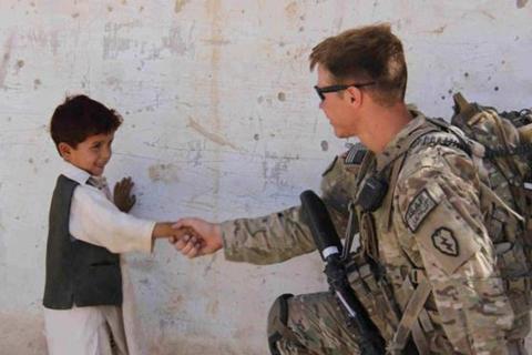 A soldier shaking hands with a boy. The Thai for "a soldier shaking hands with a boy" is "ทหารจับมือเด็กผู้ชาย". A soldier shaking hands with a boy. The Thai for "a soldier shaking hands with a boy" is "ทหารจับมือเด็กผู้ชาย".