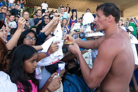 A swimmer is signing autographs. The Thai for "a swimmer is signing autographs" is "นักว่ายน้ำกำลังแจกลายเซ็น". A swimmer is signing autographs. The Thai for "a swimmer is signing autographs" is "นักว่ายน้ำกำลังแจกลายเซ็น".